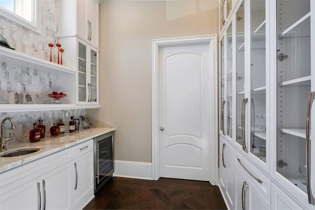 the custom pantry with glass cabinets and wine storage in a luxury home
